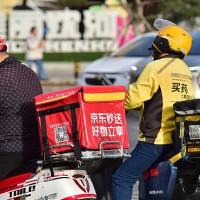 Food delivery riders of JD Takeaway , the food delivery service under China's e-commerce giant JD.com, and Meituan wait for the green light on the...