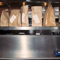 food in take out bags with receipts, sitting on restaurant shelf - junk food stock pictures, royalty-free photos & images