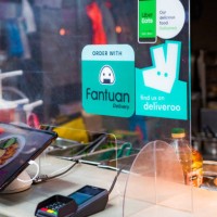 food kiosk with deliveroo and uber eats signs - junk food stock pictures, royalty-free photos & images