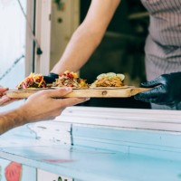 food truck owner serving tacos to male customer. - junk food stock pictures, royalty-free photos & images