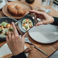 foodie photographing food at restaurant and share on social media - food stock pictures, royalty-free photos & images