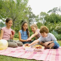 four children having picnic in garden (8-12) - garden decoration stockfoto's en -beelden