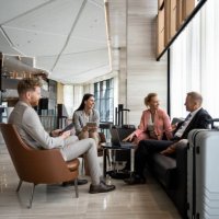 four colleagues sitting in a luxury hotel lobby and preparing for a business meeting. - travel stock pictures, royalty-free photos & images