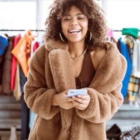 fröhliche influencerin im kunstpelzmantel - fashion stock-fotos und bilder