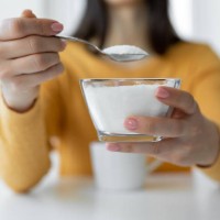 frau fügt raffinierten zucker zu einer tasse kaffee hinzu - food stock-fotos und bilder
