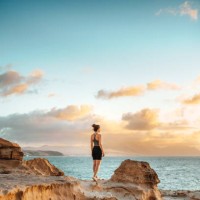 frau steht auf einer klippe mit blick auf den spektakulären sonnenuntergang - travel stock-fotos und bilder