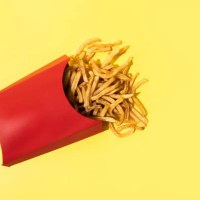 french fries on yellow background - junk food stock pictures, royalty-free photos & images