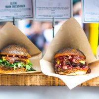 fresh flame grilled burgers displayed in a row at food market - junk food stock pictures, royalty-free photos & images