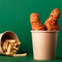 fried crispy chicken legs, drumsticks in craft paper cup on green - junk food stock pictures, royalty-free photos & images