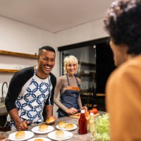 friends cooking and talking on hamburger night at home - junk food stock pictures, royalty-free photos & images