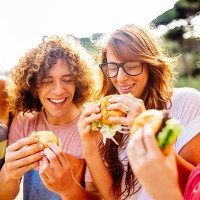 friends eating burgers - junk food stock pictures, royalty-free photos & images