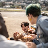 friends eating pizza in the park - junk food stock pictures, royalty-free photos & images