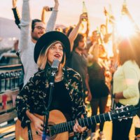 friends enjoying a guitar performance on the rooftop - concert stock pictures, royalty-free photos & images
