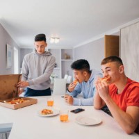 friends enjoying a take-away pizza - junk food stock pictures, royalty-free photos & images