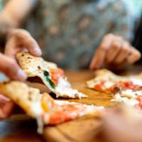 friends getting slices of pizza, using hands - food stock pictures, royalty-free photos & images