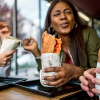 friends having lunch together in a fast-food restaurant - junk food stock pictures, royalty-free photos & images