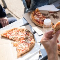friends having pizza outdoors - junk food stock pictures, royalty-free photos & images