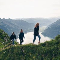 friends hike up grassy mountain ridge at sunrise - travel stock pictures, royalty-free photos & images