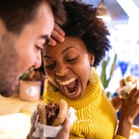 friends playing while eating a burger - junk food stock pictures, royalty-free photos & images