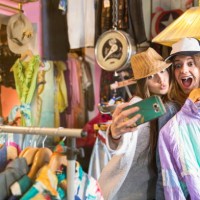 friends taking selfie in thrift store - fashion stock-fotos und bilder