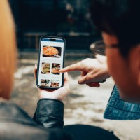 friends using mobile food delivery app to browse menu and order online - junk food stock pictures, royalty-free photos & images