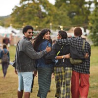 friends walking side by side with arms around at park - concert stock pictures, royalty-free photos & images