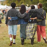 friends with arms around walking side by side at park - concert stock pictures, royalty-free photos & images