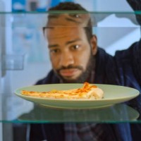 frowning man looking slice of pizza - junk food stock pictures, royalty-free photos & images