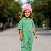 full-length portrait of a blonde, caucasian girl, wearing a woolen cap, smiling. with a park in the background. children, free time, vacations and leisure concept. - fashion stock pictures, royalty-free photos & images