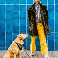 full length of happy young man with dog standing against blue tiled wall - fashion stock pictures, royalty-free photos & images