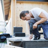 full length of man using cordless screwdriver nail into floorboard - home decoration stock pictures, royalty-free photos & images