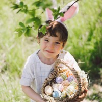 funny boy with eggs basket and bunny ears on easter egg hunt in sunny spring garden - garden decoration stock pictures, royalty-free photos & images
