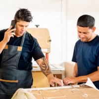 furniture manufacturing business owner talking on phone in workshop - home decoration stock pictures, royalty-free photos & images