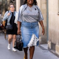 Gabriella Karefa-Johnson is seen wearing black sunglasses, a black leather Prada bag, black and yellow shiny pumps, pendant gold earrings, a chain...