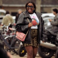 Gabriella Karefa-Johnson wears animal print mini skirt, white shirt with a print and black leather jacket and oran or pink Chanel bag outside Chanel...