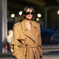 Gabrielle Caunesil wears black sunglasses, light brown double breasted belted trench coat, outside Stella McCartney, during the Paris Fashion week...