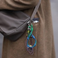 Gaius Okami seen wearing a brown long wool coat, grey hat, white blouse, sweater vest, beige brown Prada bag with details and black wide pants,...