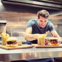 gelukkig chef-kok schikken hamburger en frietjes - junk food stockfoto's en -beelden