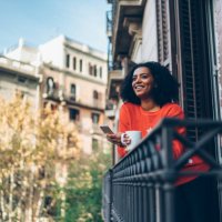 gemischte rennfrau im weihnachtsurlaub in barcelona sms auf der terrasse - travel stock-fotos und bilder