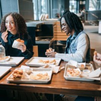 gen z friends eating food at local venue - junk food stock pictures, royalty-free photos & images