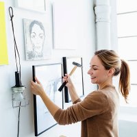 germany, bavaria, munich, young woman holding picture frame in front of wall - home decoration stock pictures, royalty-free photos & images