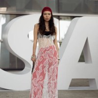 Geust wears red wide Adidas pants, black bikini top, white lace dress, red beanie and Louise Vuitton bag on day 2 of Visa Fashion Week Almaty 2024 on...
