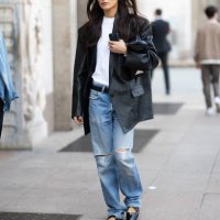Giorgia Tordini wears black shiny leather ballerinas, silver hoop earrings, black sunglasses, a black belt, a black oversized leather jacket, a white...