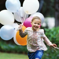 girl (8-9) running with a bunch of balloons - garden decoration stockfoto's en -beelden