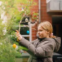 girl decorating a tree in the garden with colourful easter eggs - garden decoration stock pictures, royalty-free photos & images