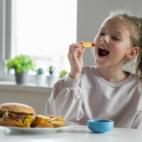 girl eating french fries with tomato ketchup - junk food stock pictures, royalty-free photos & images