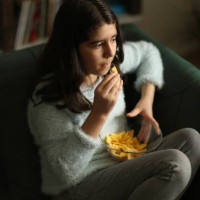 girl eating potato crisps - junk food stock pictures, royalty-free photos & images