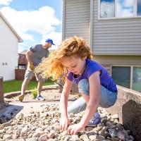 girl helping dad put landscaping rock in front of house - home decoration stock pictures, royalty-free photos & images