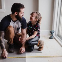 girl helping father install floor tiles - home decoration fotografías e imágenes de stock