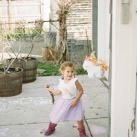 girl in unicorn dress swinging at a piñata - garden decoration stock pictures, royalty-free photos & images
